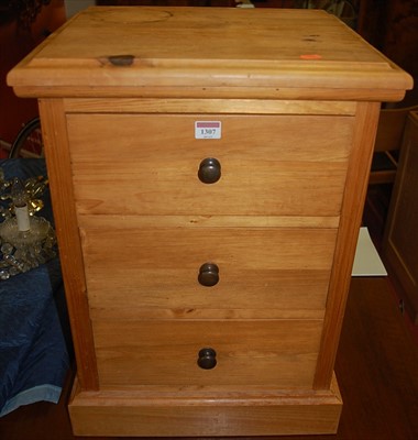 Lot 1307 - A contemporary pine three drawer bedside chest,...