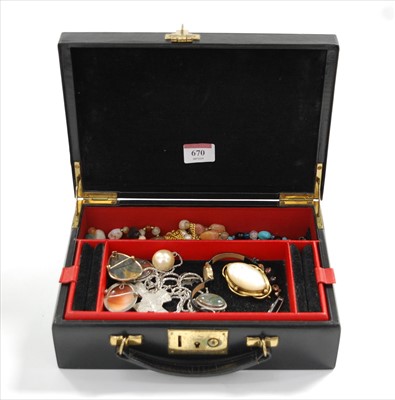 Lot 670 - A leather clad jewellery box and contents, to...