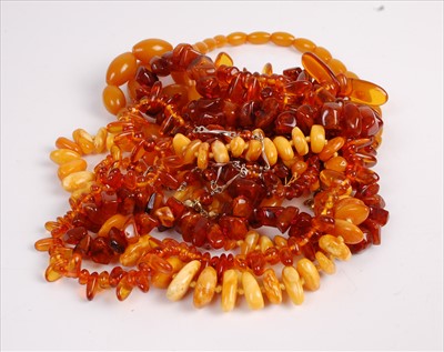 Lot 543 - Assorted clear and orange amber beads, and a...