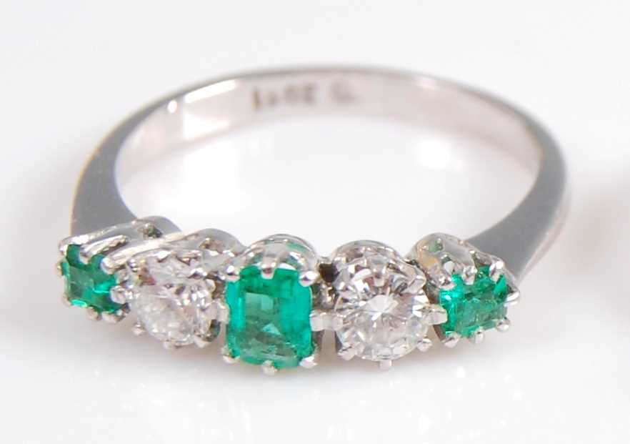 Lot 2002 - A white metal, emerald and diamond five stone...