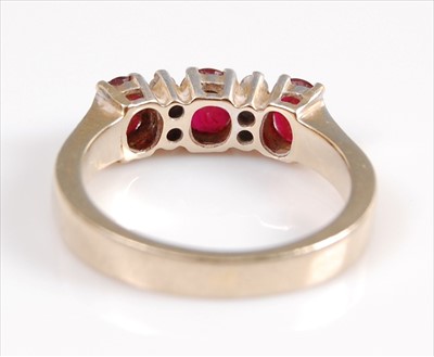Lot 2066 - A yellow metal, ruby and diamond seven stone...