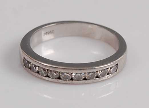 Lot 1204 - A platinum diamond half-hoop eternity ring,...