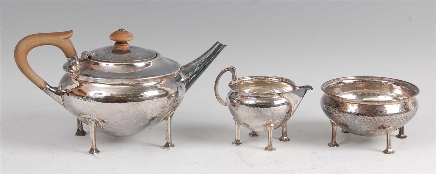 Lot 124 - An early Art Deco silver hammered three-piece...