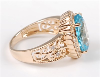 Lot 1228 - A yellow metal, blue topaz and diamond oval...