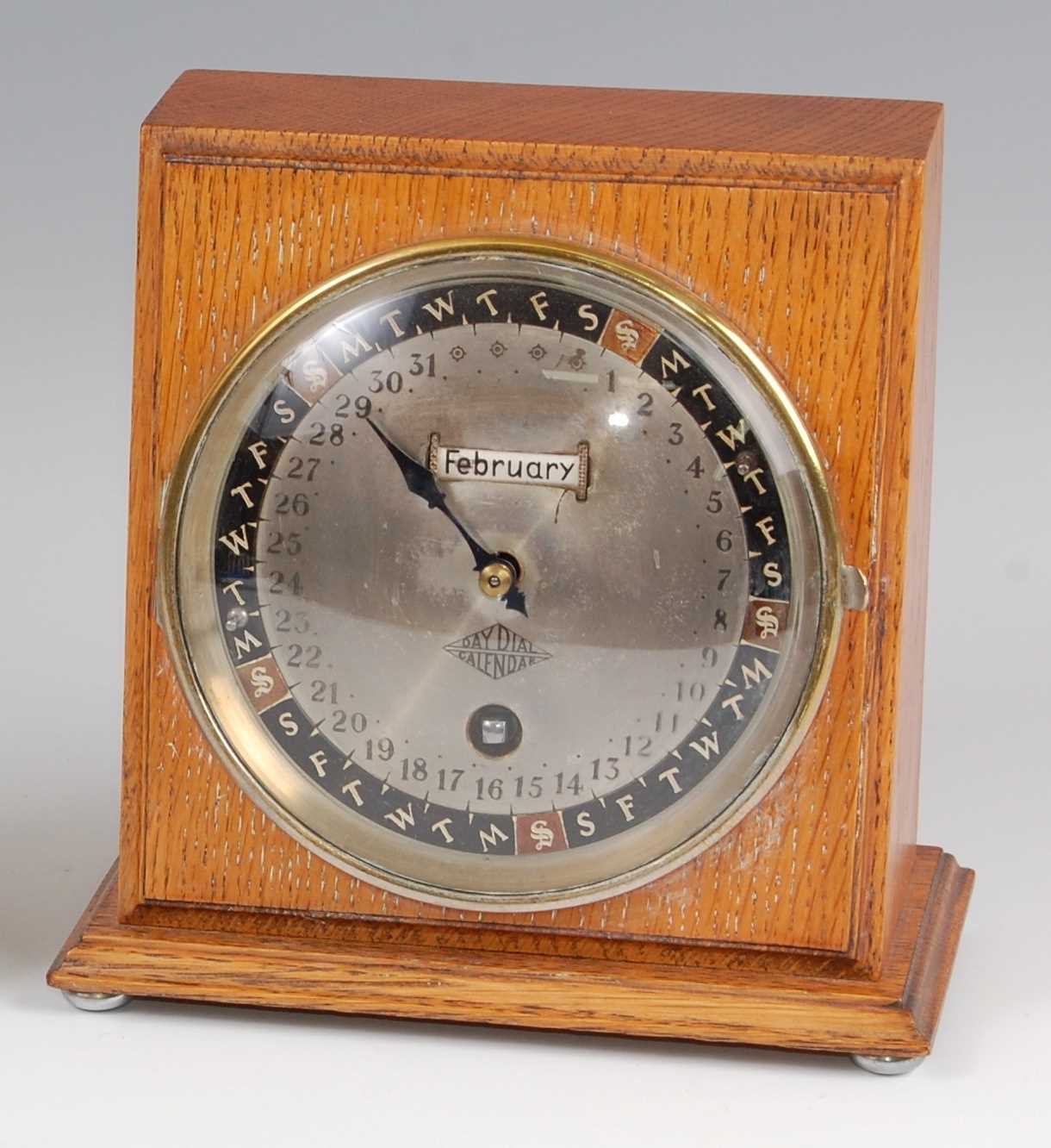 Lot 183 - An Art Deco oak desktop day-dial calendar, the...