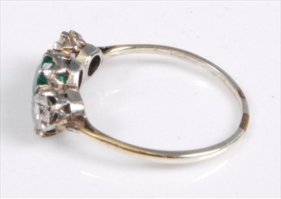 Lot 1193 - A white metal, emerald and diamond three-stone...