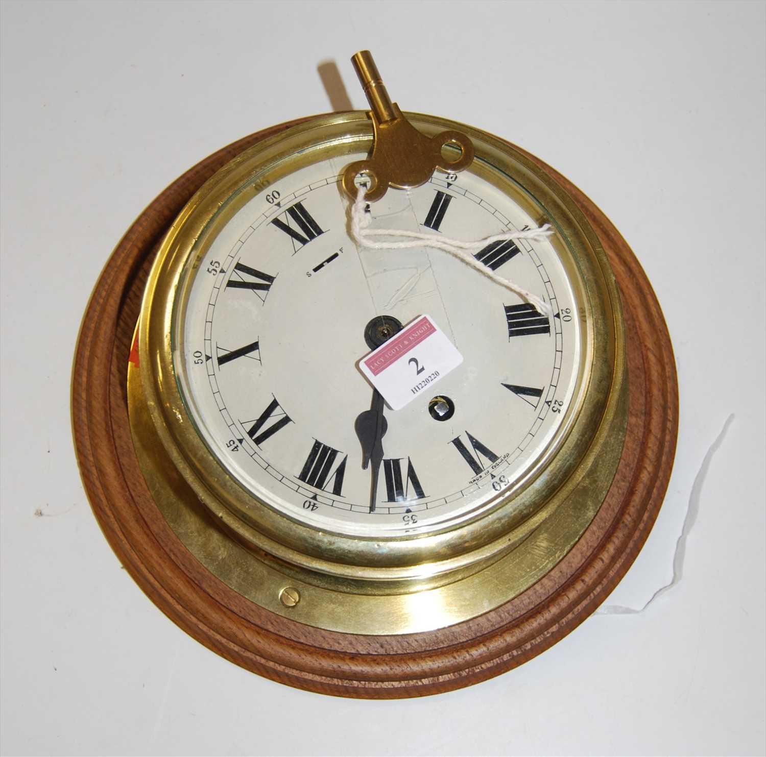 Lot 2 - A brass cased ships clock, having an enamelled...