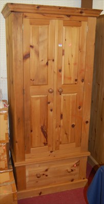 Lot 1106 - A modern pine double door wardrobe having...