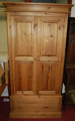 Lot 1117 - A modern pine double door wardrobe having...