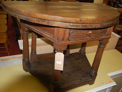 Lot 1187 - An antique joined oak demi lune fold-over...