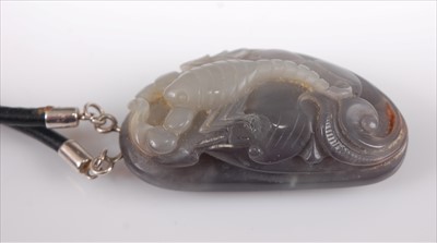 Lot 395 - A Chinese carved jade pendant having purple...