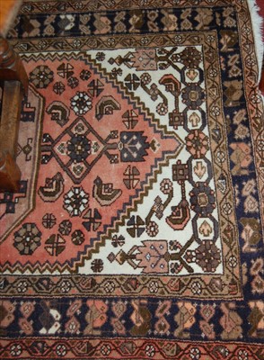 Lot 1125 - A Persian woollen rug, having a geometric...