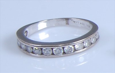 Lot 1243 - A white metal diamond half hoop eternity ring,...