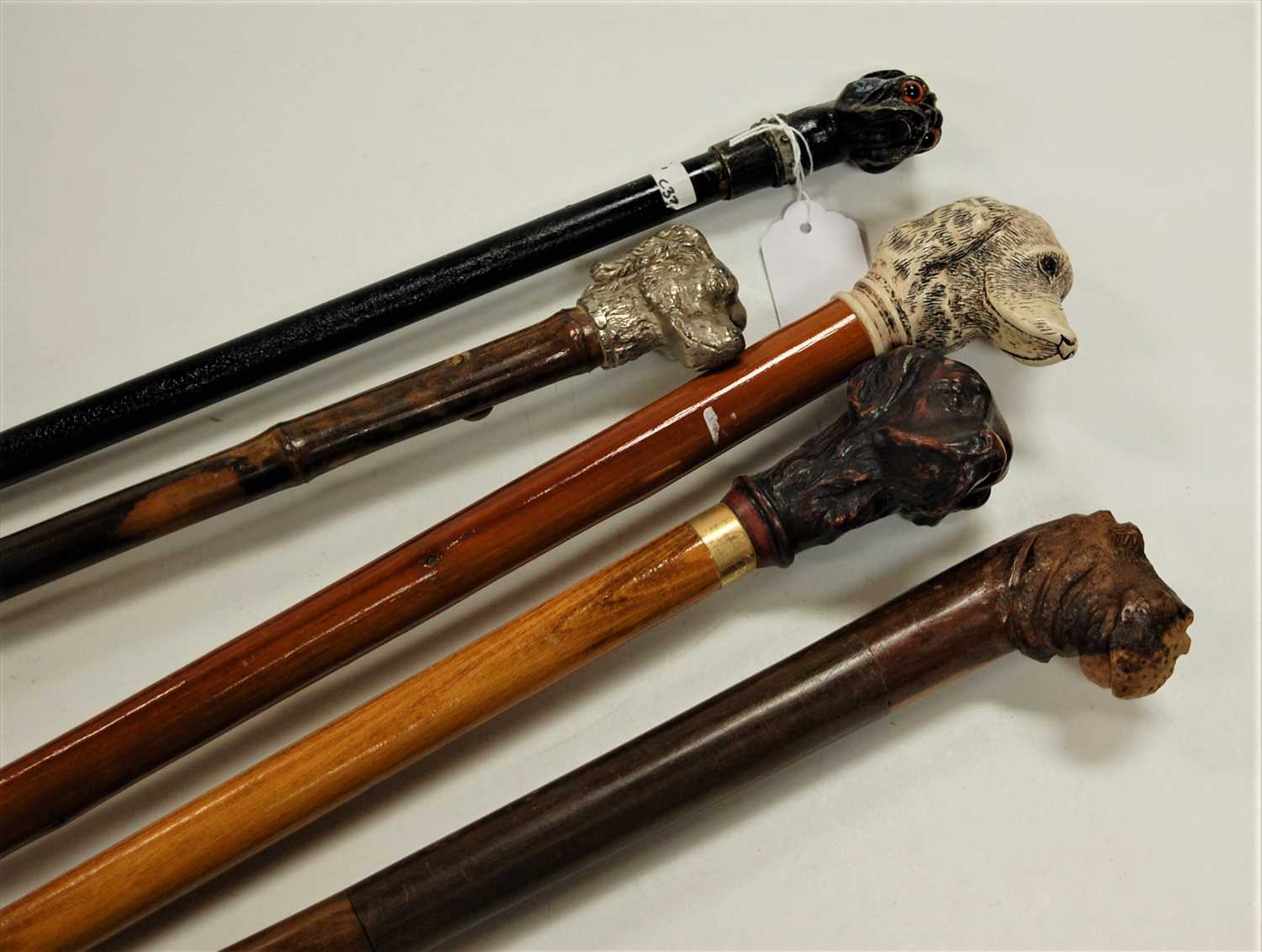 Lot 114 - An ebonised walking cane, the handle in the...