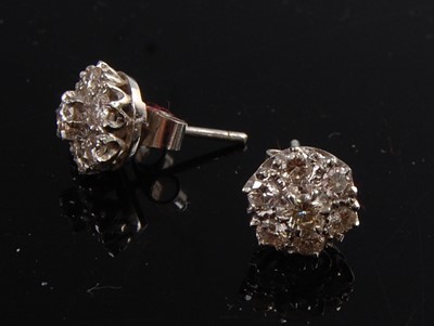Lot 1261 - A pair of white metal diamond circular cluster...