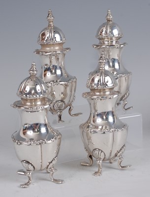 Lot 1106 - An Edwardian set of four silver pepperettes,...