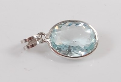 Lot 1198 - A white metal and aquamarine pendant, the oval...