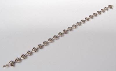 Lot 2506 - A 9ct white gold diamond line bracelet,...