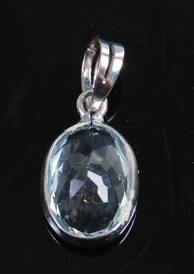 Lot 2590 - A white metal oval aquamarine pendant, the...
