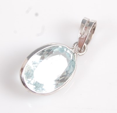 Lot 2590 - A white metal oval aquamarine pendant, the...