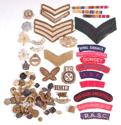 Lot 33 - A collection of cap badges, buttons and cloth shoulder titles to include