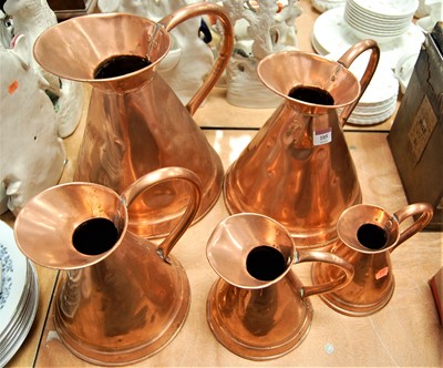 Lot 105 - A graduated set of five copper flagons, height...