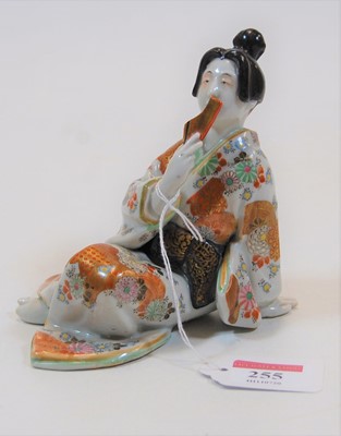 Lot 255 - A Japanese porcelain figure of a Geisha, posed...