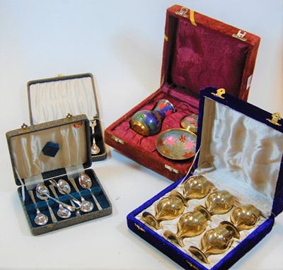 Lot 264 - A cased set of brass floral enamel decorated...