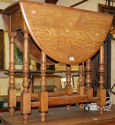 Lot 1239 - A 1920s oak dropleaf occasional table, having...