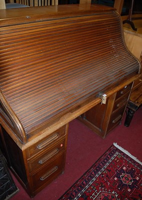 Lot 1348 - An early 20th century oak roll top desk, width...