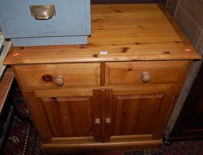 Lot 1379 - A modern pine double door side cupboard having...