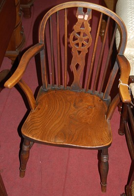Lot 1406 - A late 19th century elm wheelback elbow chair,...