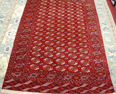 Lot 1503 - A Persian woollen Bokhara rug, the red ground...