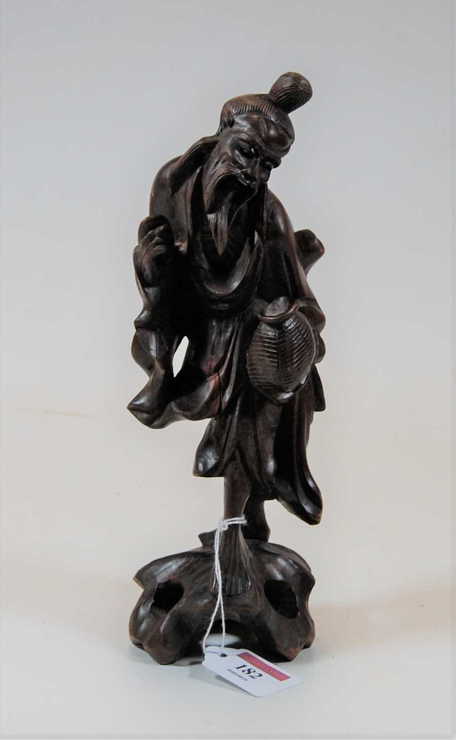 Lot 182 - A Chinese softwood carving of a peasant figure,...