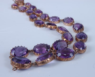 Lot 1236 - A yellow metal amethyst necklet, featuring 24...