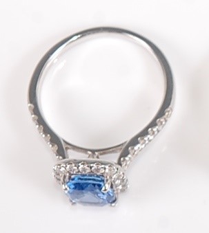 Lot 1268 - A white metal, sapphire and diamond halo...