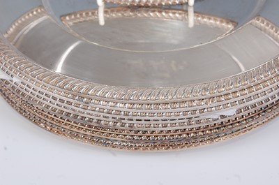 Lot 1174 - A set of twelve silver plated dinner plates,...