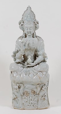 Lot 1365 - A Chinese celadon glazed stoneware deity, in...