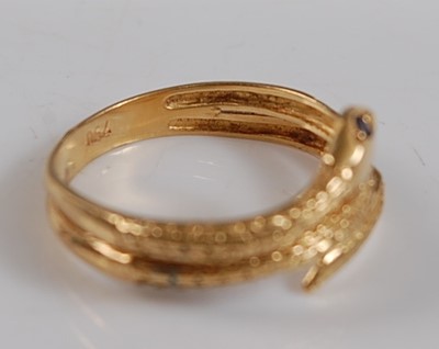 Lot 2650 - A yellow metal snake ring, the head set with...