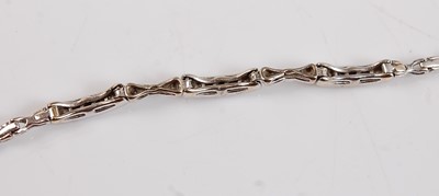 Lot 2600 - A white metal diamond line bracelet, featuring...