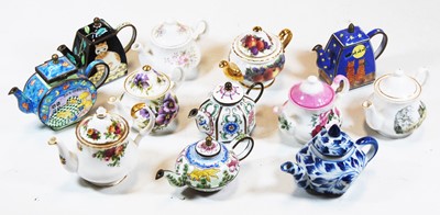 Lot 205 - A collection of miniature teapots in china and...