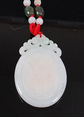 Lot 2534 - A large oval carved white jadeite pendant,...