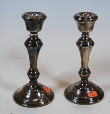 Lot 260 - A pair of turned silver candlesticks on loaded...