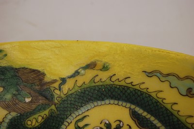 Lot 128 - A Chinese export yellow glazed charger,...