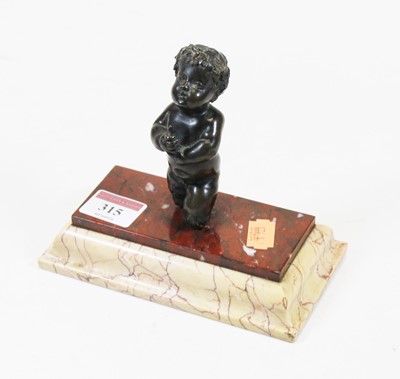 Lot 315 - A small bronze figure of a cherub, in kneeling...