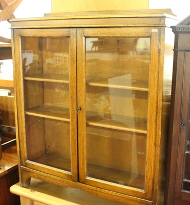 Lot 1225 - An early 20th century oak glazed bookcase,...