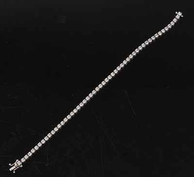 Lot 2216 - An 18ct white gold diamond tennis bracelet,...