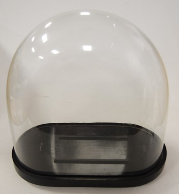 Lot 38 - A glass clock dome on an oval ebonised plinth,...
