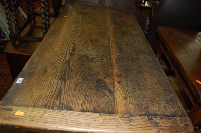 Lot 1344 - A provincial elm dining table, the twin plank...