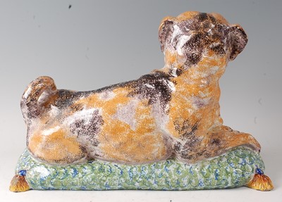 Lot 2063 - A French faience model of a recumbent pug dog...